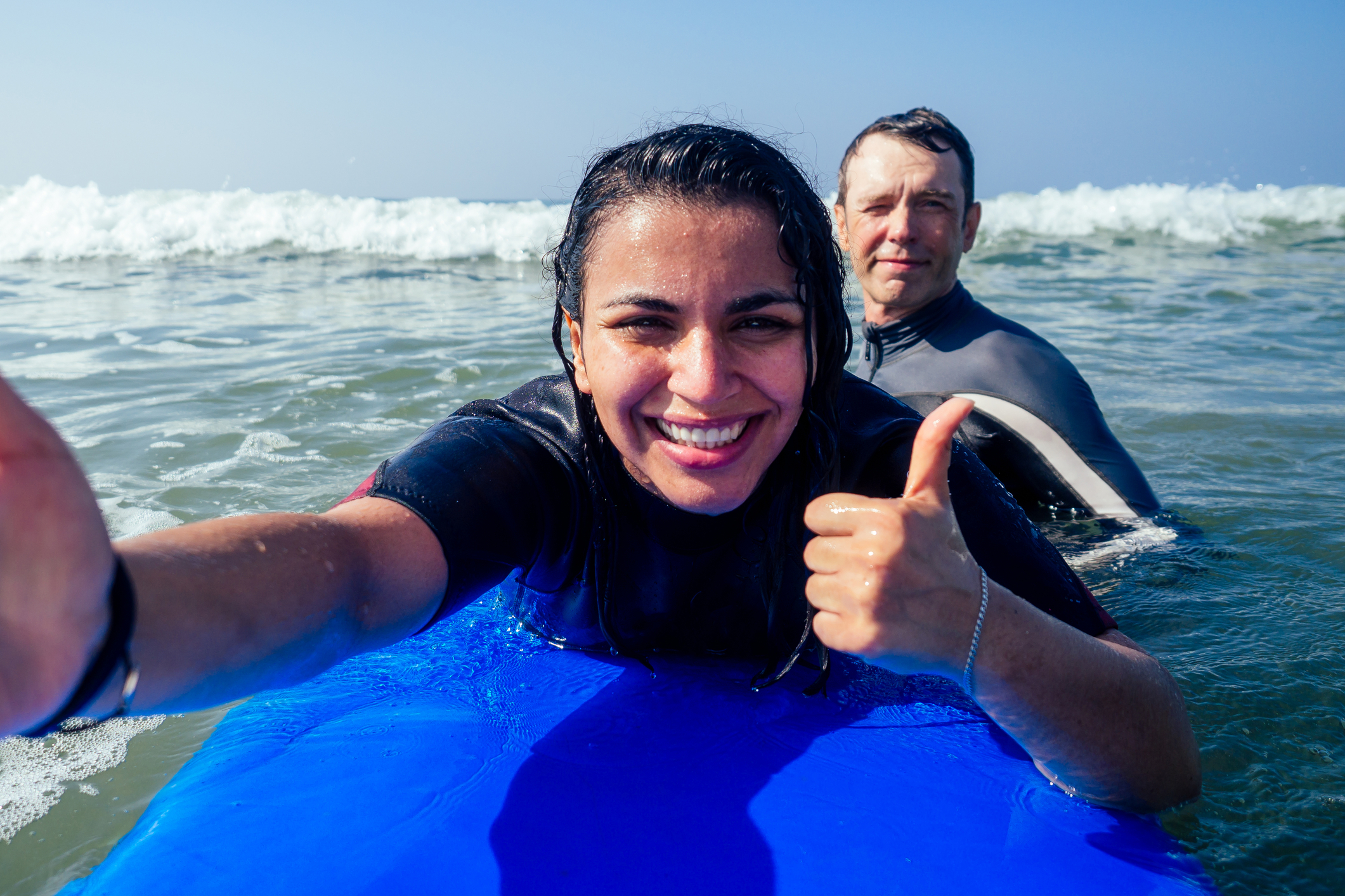 surf lesson girl and instructor thumbs up